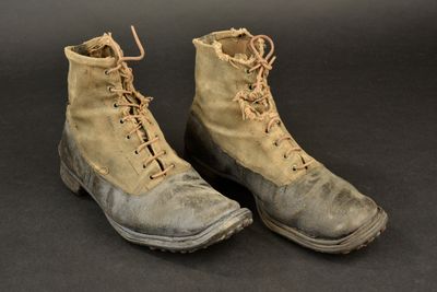 an old pair of military boots on a black surface