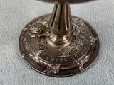a silver plate with a bird on it sitting on a table