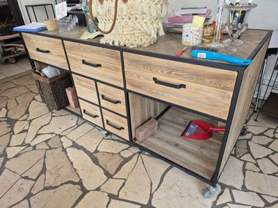 une grande commode en bois avec des tiroirs, sur laquelle est posé un sac