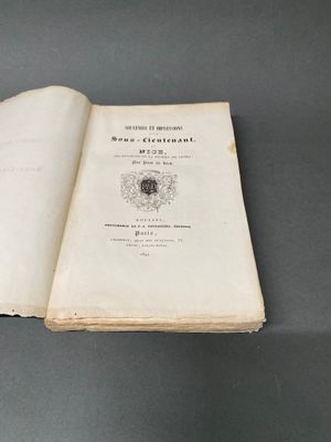 un livre ouvert posé sur une table, sur une surface grise