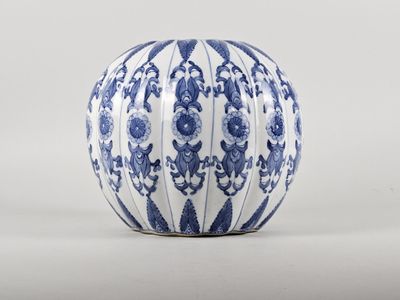 vase en porcelaine bleue et blanche orné de motifs floraux sur fond blanc