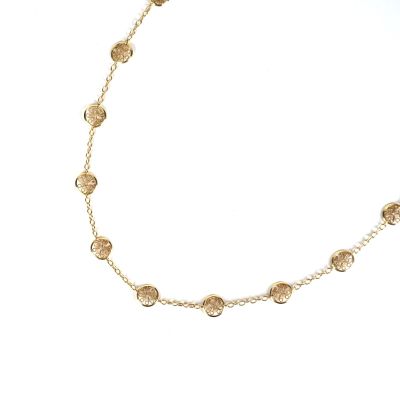 gros plan d'un collier en or sur fond blanc