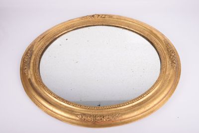 une image représentant un miroir à cadre doré posé sur une surface blanche