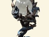 une statue représentant un homme tenant une boule de cristal ornée d'oiseaux