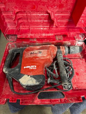une image représentant une boîte à outils rouge contenant une perceuse et d'autres outils