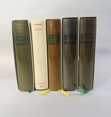 four books are lined up in a row on a white surface
