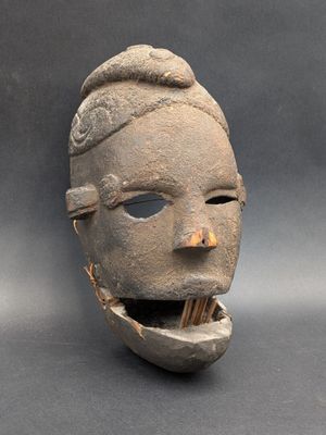 une image représentant un masque en argile avec une dent dans la bouche