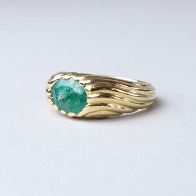 an image of a gold ring with a green stone on it