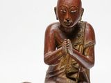 une image représentant la statue d'un homme assis par terre