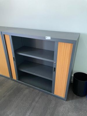 a bookcase with two shelves and a trash can next to it