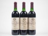 trois bouteilles de vin rouge posées l'une à côté de l'autre sur une surface blanche