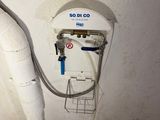 an image of a bathroom with a water heater attached to the wall