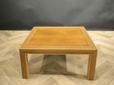 a wooden table with a square top on a wooden floor