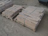 Plusieurs palettes de bois sont empilées sur une palette dans un parking