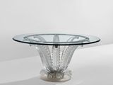 a round glass table with a metal base and a clear glass top
