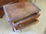 a small wooden table with two drawers on it