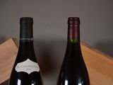 two bottles of wine sitting next to each other on a table