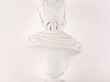 a statue of an owl sitting on top of a busturine