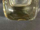 a clear glass vase with a small amount of liquid in it