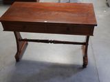 a small wooden table with a drawer on top of it