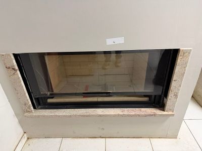 a fire place in the corner of a room with a tile floor
