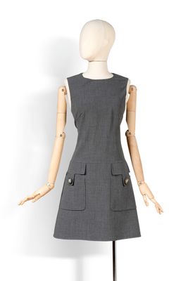Le mannequin porte une robe grise dotée de poches.