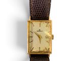 gros plan d'une montre-bracelet avec un bracelet en cuir marron