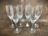 four empty wine glasses sitting on top of a table next to each other