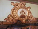 a gold clock with a picture of a woman on it