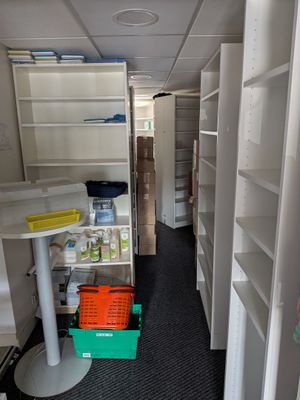 une petite pièce avec des étagères et une table à l'intérieur