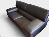 un canapé en cuir noir posé sur une surface blanche