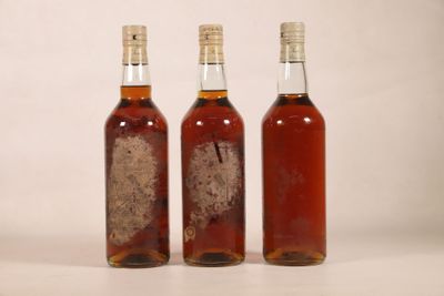 trois bouteilles d'alcool placées les unes à côté des autres sur une table