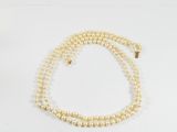 gros plan d'un collier de perles sur une surface blanche