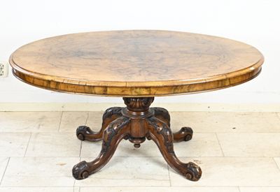 une table ronde avec un plateau en bois posée sur un sol carrelé