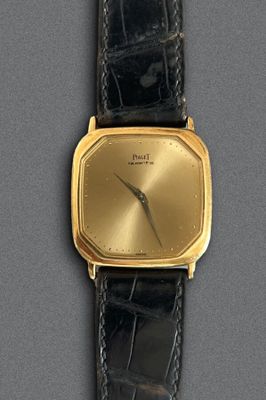 une image d'une montre-bracelet plaquée or avec un bracelet en cuir noir