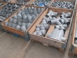 des cartons contenant des raccords de tuyauterie de différentes tailles et formes dans un entrepôt