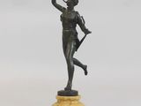 statue en bronze représentant une femme tenant un arc et une flèche, posée sur un socle en marbre