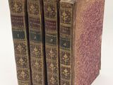 three old books sitting on top of each other on a white surface