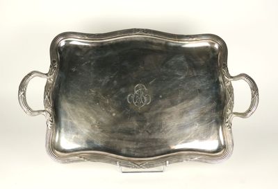 un plateau ancien en argent avec des poignées et des anses sur fond blanc