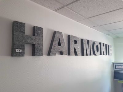 a sign that says harmony hanging on the wall