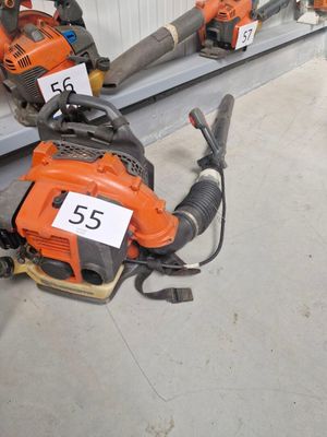 Plusieurs tronçonneuses sont alignées sur une étagère dans un magasin