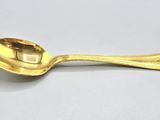 a close up of a gold spoon on a white surface