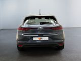 the rear end of a grey car in a white room
