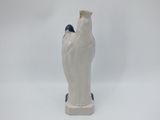 a white vase with a bird on it on a white background
