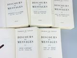six books on a table with a pen on top of them