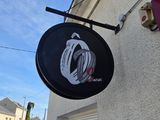 une enseigne accrochée sur le mur d'un immeuble, face à la rue