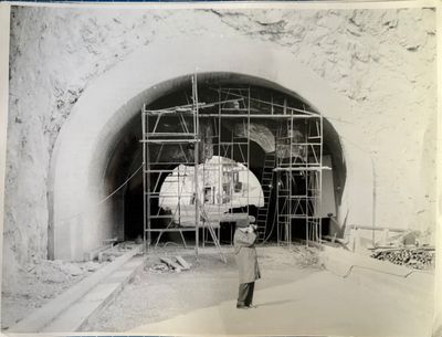 an old black and white photo of a man standing in front of a tunnel