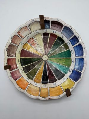a plate with a colorful wheel on it on a white surface