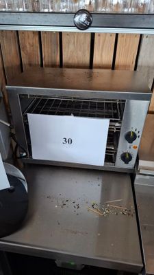 a toaster oven sitting on a table with a sign on it