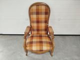 une vieille chaise dont le dossier et les accoudoirs sont recouverts d'un tissu à carreaux